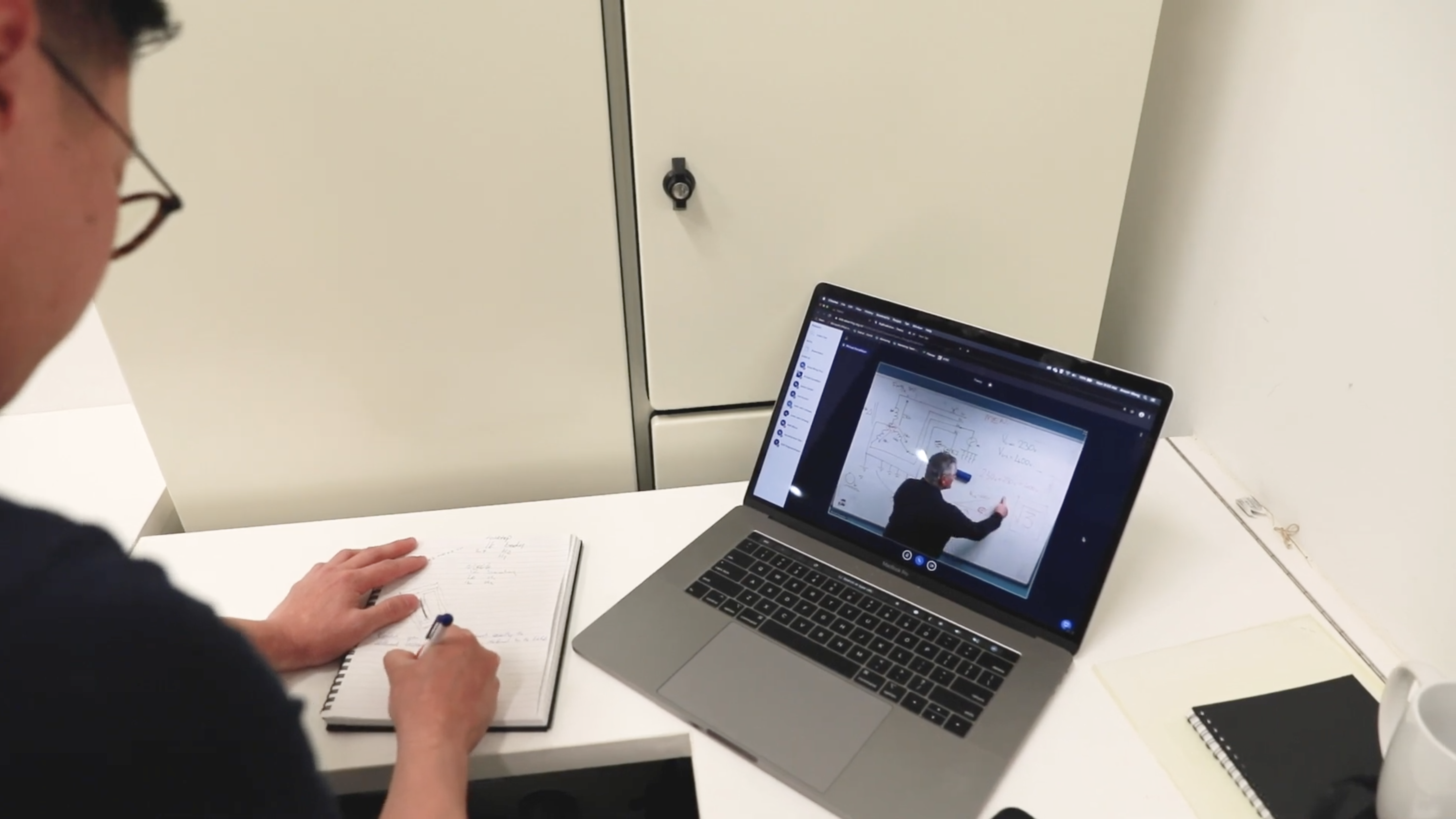 Student watching a virtual class on his laptop